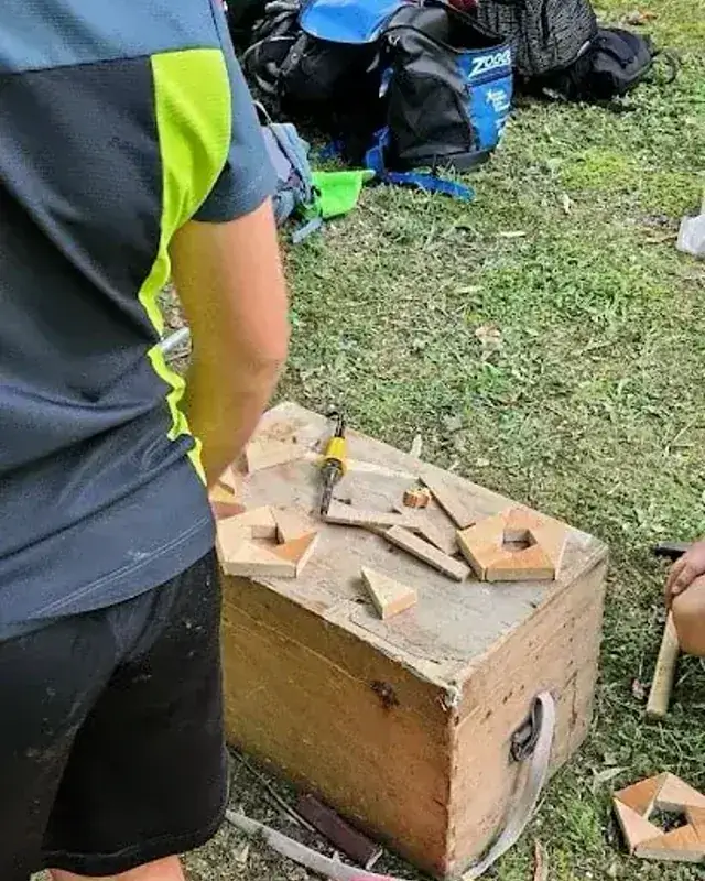 Un bambino osserva le forme di legno preparate sul banco all’aperto.